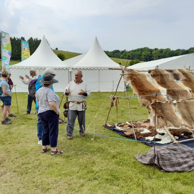 Visitors looking at animals skins, Roman and Iron Age Britain Living History at the Chalke Valley History Festival 2022
